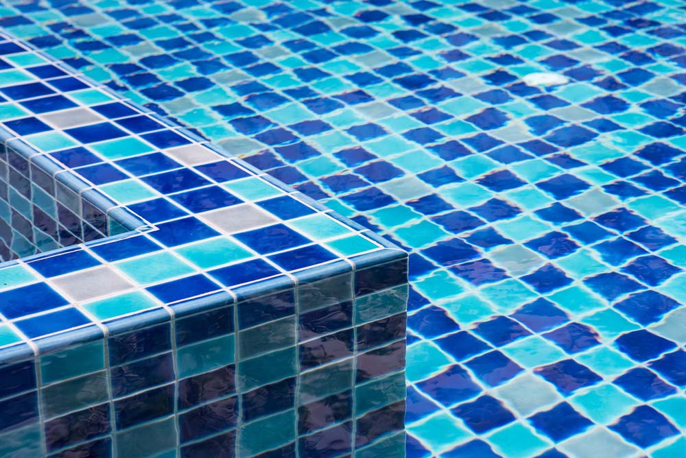 Üvegmozaik burkolatok a medence különleges kialakításáért